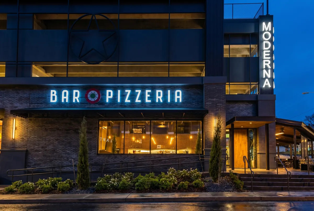 Night exterior of Moderna Bar & Pizzeria on West 6th Street, Austin